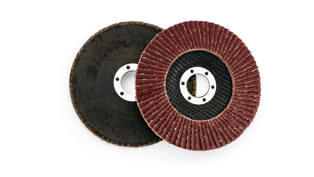 2 angle grinder discs placed on the white surface against each other.